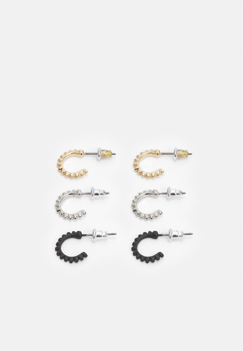 Conjunto de quatro brincos: dourados, prateados e pretos. Cada um tem uma forma curva com detalhes texturizados. Os materiais incluem metal e borracha.