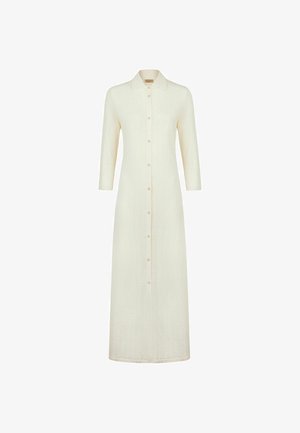 Robe longue crème boutonnée, manches trois-quarts et col pointu, avec des détails discrets de coutures verticales.