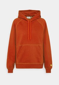 Sudadera de color óxido con bolsillo tipo canguro en el frente, capucha ajustable con cordón, puños acanalados y pequeño logo amarillo en el puño izquierdo.