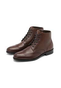 Stivali ankle in pelle marrone con dettagli brogue, caratterizzati da punte rotonde, sei asole e una finitura liscia. Suole in gomma nera offrono aderenza.