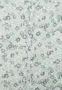 Tessuto floreale con sfondo verde chiaro, caratterizzato da motivi verde scuro e grigi. Texture liscia con dettagli di cucitura fine.