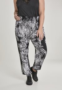 Zwart-wit gestreepte wijde broek met een elastische tailleband, voorzien van een textuur die lijkt op penseelstreken.