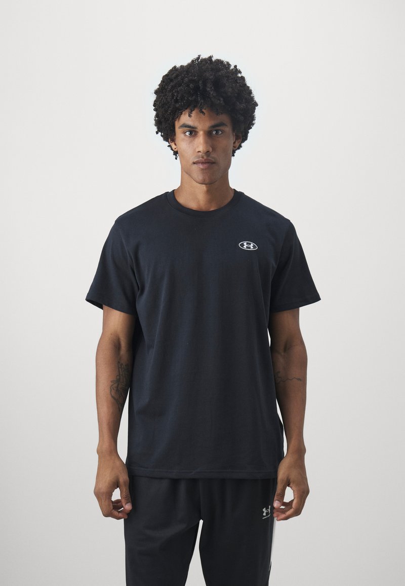 Schwarzes Baumwoll-T-Shirt mit Rundhalsausschnitt und kurzen Ärmeln, das ein kleines graues Logo auf der Brust und einen lässigen Schnitt bietet.