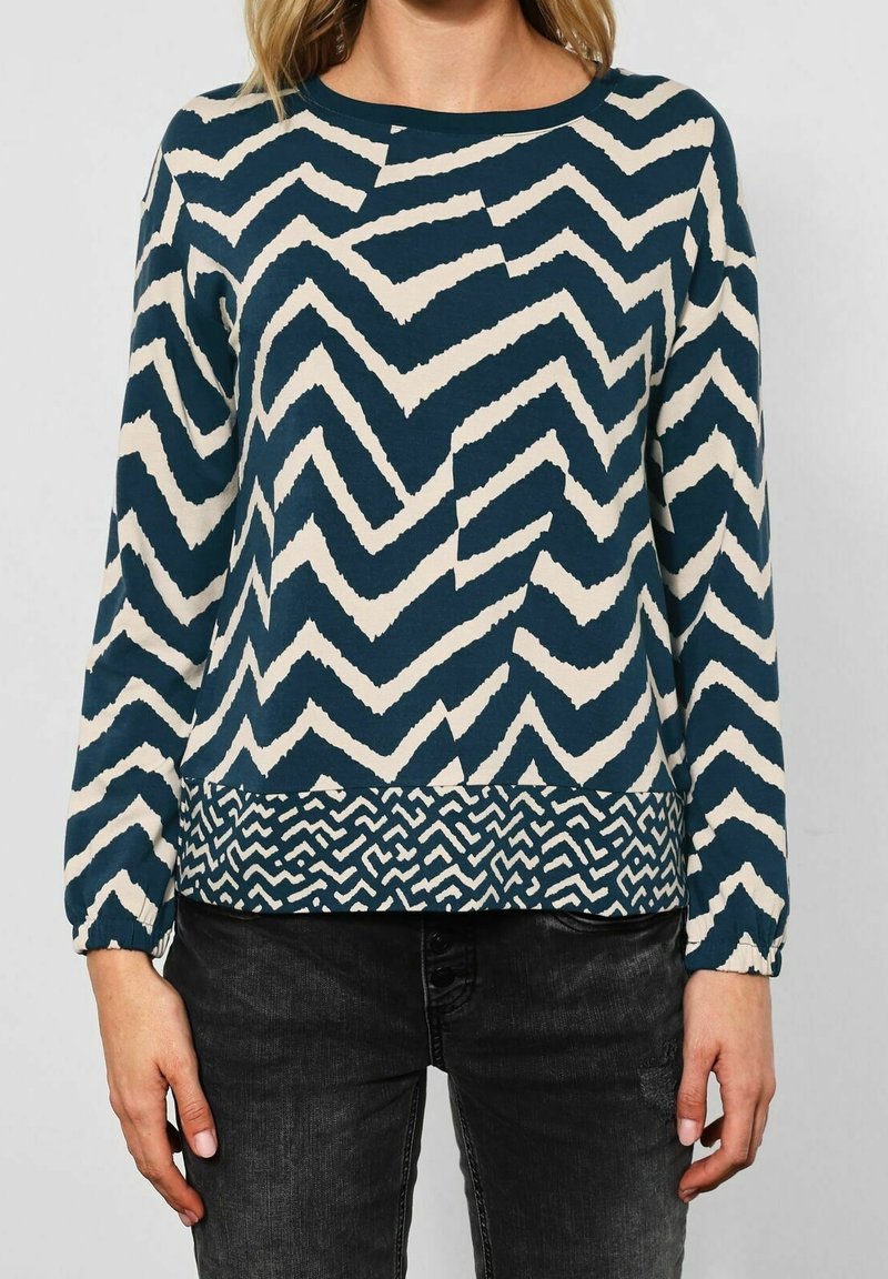 Maglione a maniche lunghe in navy e crema con un motivo a zigzag e orlo testurizzato. Presenta polsini elasticizzati e scollatura rotonda.