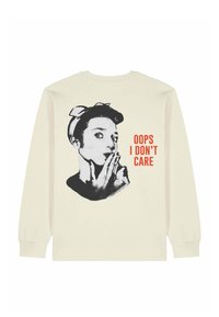 Chemise crème à manches longues avec un graphique noir et blanc d'une femme chuchotant et un texte rouge disant "OOPS I DON’T CARE" au dos.
