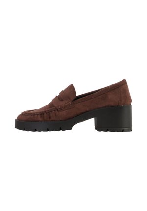 Mocassin en daim marron avec talon noir épais et semelle crantée épaisse, avec un détail de bride cousue sur le dessus.