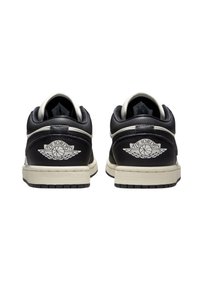 Svarta lädersneakers med en krämfärgad mellansula, med en vit "Air Jordan"-logga och vingemblem på hälen. Låg toppdesign med runda snören.