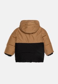 Giaccone imbottito con la parte superiore beige e la parte inferiore nera. Dotato di cappuccio e polsini elastici. Tessuto sintetico liscio con una texture trapuntata.