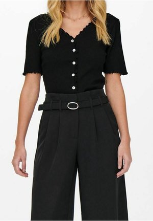 Haut noir à manches courtes côtelé avec des bords festonnés et des boutons blancs, associé à un pantalon noir taille haute avec une ceinture à boucle ovale.