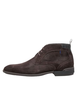 Dark brown suede men's ankle boot with lace-up front, black textured heel detail, and pull tab on white background.