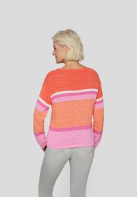 Bunter Strickpullover mit horizontalen Streifen in verschiedenen Orangetönen, Rosa und Weiß, mit lockerer Passform und Rundhalsausschnitt.