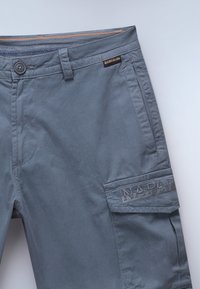 Grey cargo shorts featuring a front button closure, side pocket, and stitched logo detail on the leg. Made from lightweight fabric.