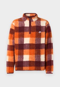Nike pūkinys su oranžine, burgundine, ir kreminine patikrinta raštu, ketvirčio užtrauktuku ir išsiuvinėtu logotipu kairėje krūtinės pusėje.