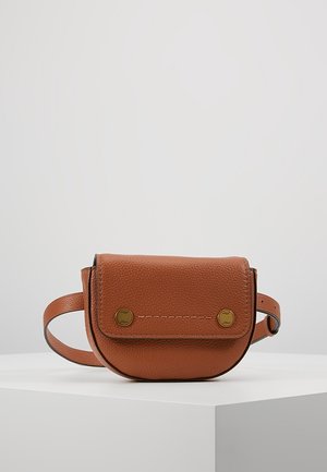Petit sac ceinture en cuir marron avec rabat fermé par deux boutons en laiton, sangle ajustable et texture grainée, présenté sur une surface blanche.