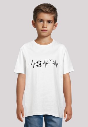 Weißes Baumwoll-T-Shirt mit einem grafischen Druck eines Fußballs, einer Herzschlaglinie und einem Herzsymbol in schwarzer Farbe über die Brust. Kurze Ärmel.
