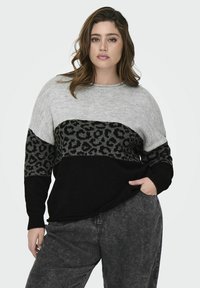 Leopardų raštuotas megztinis pilkos, juodos ir smėlio spalvų; mezginio tekstūra; plati rankovė; laisvas siluetas; kontrastingi spalvų blokai.