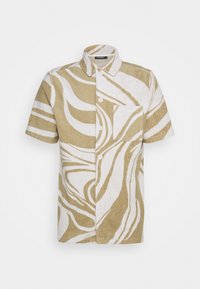 Chemise à manches courtes boutonnée avec motif abstrait ondulé beige et blanc et poche poitrine sur fond uni.