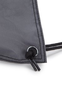 Grå stofpose hjørne med en metaløje, sort snor og tekstureret overflade med synlige sømdetaljer.