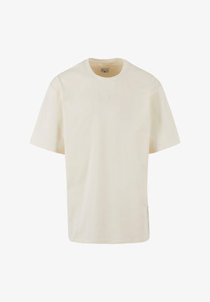 Krämfärgad bomulls t-shirt med korta ärmar, rund hals och subtilt broderad logotyp på bröstet. Mjuk textur och avslappnad passform.