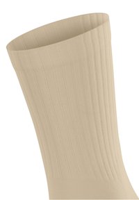 Beige gestreifte Socke mit einem hohen Bündchen, hergestellt aus weichem Stoff, bietet eine glatte Textur und gleichmäßige Farbe über die gesamte Socke.