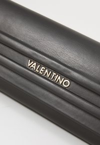 Black leather wallet featuring a quilted texture and a gold logo detail reading "VALENTINO" on the front.