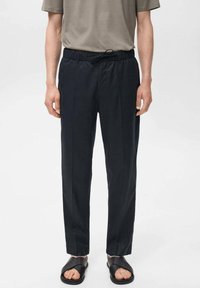 Zwarte, losvallende broek met een verstelbare tailleband en zijzakken, gemaakt van een lichtgewicht stof met een gladde textuur.