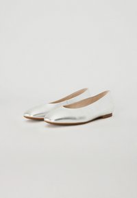 Ballerines métalliques argentées avec une texture lisse, un bout arrondi, un talon bas et un design simple. Accents de couture subtils le long des bords.