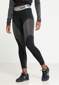 Leggings Nike Pro neri con un design a pannelli testurizzati e accenti grigi, una vita alta e una finitura liscia per un aspetto snello.