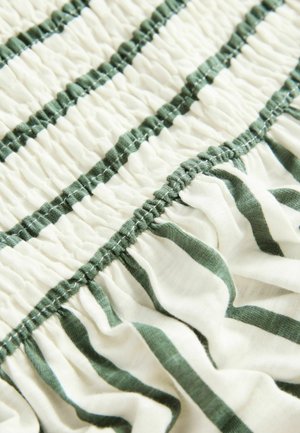 Bavlnená tkanina s naťahovanou textúrou, so striedavými zelenými pruhmi na krémovom pozadí, vykazujúca elasticitu a volánové detaily.