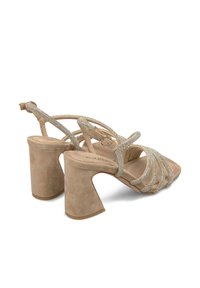 Sandali beige con tacco, realizzati in suede, caratterizzati da fascette incrociate adornate da strass e un tacco a blocco per stabilità.