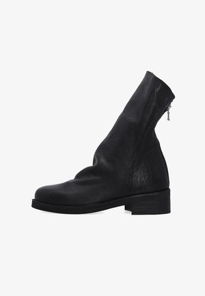 Černé kožené kotníkové boty s kulatou špičkou, zúženou vrchní částí a bočním zipem. Mají nízký, obdélníkový podpatek a hladkou texturu.