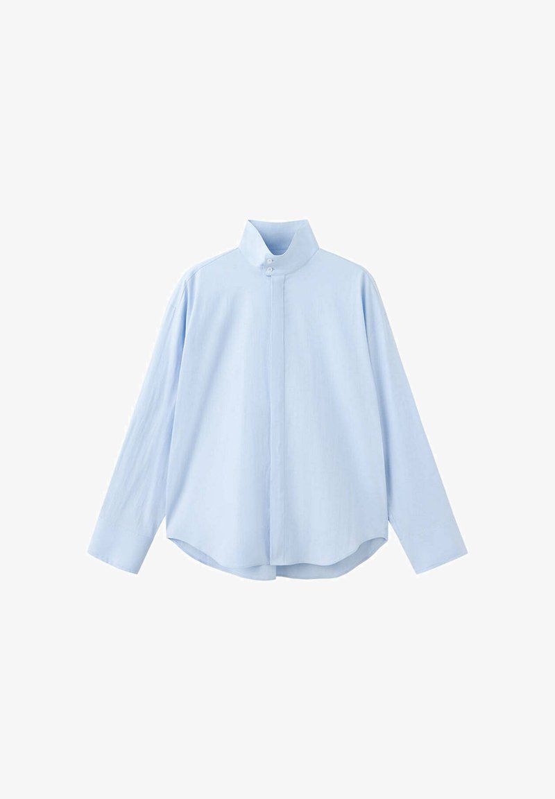 Chemise bleu clair à manches longues avec col montant et boutons cachés sur le devant, ourlet légèrement arrondi et fermeture par bouton au niveau de l'encolure.