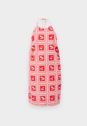 Robe halter rouge avec un motif de cerises répétitif, encadrée par des carrés et des points blancs, fabriquée en tissu léger. Liens ajustables au cou.