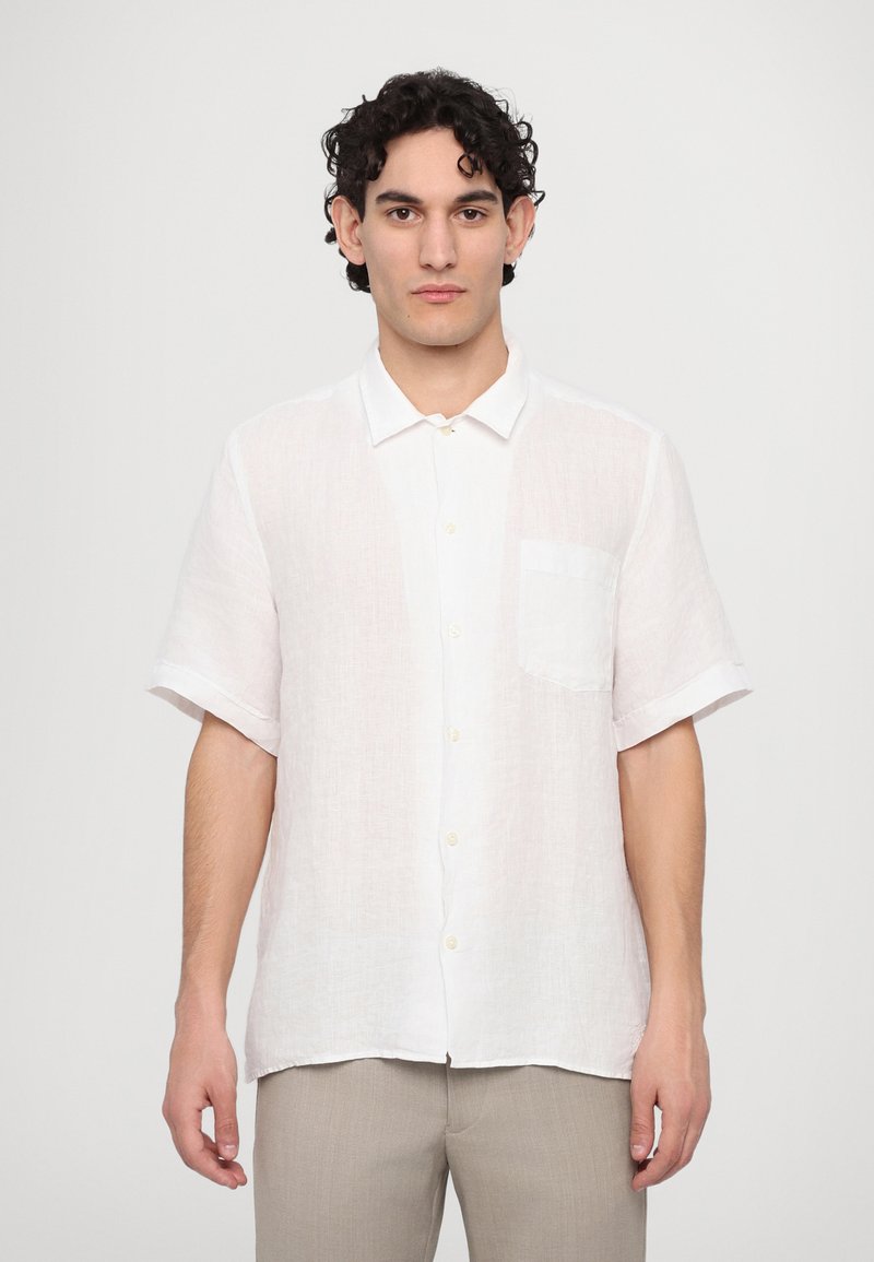 Camisa de lino blanca de manga corta con cuello abotonado, un bolsillo en el pecho y un corte relajado con mangas enrolladas.