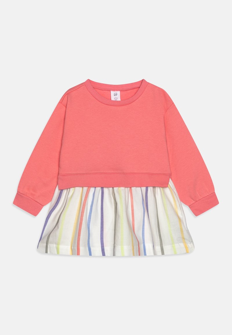 Robe pour tout-petit avec haut en sweat-shirt corail à manches longues et jupe blanche ornée de rayures arc-en-ciel verticales.