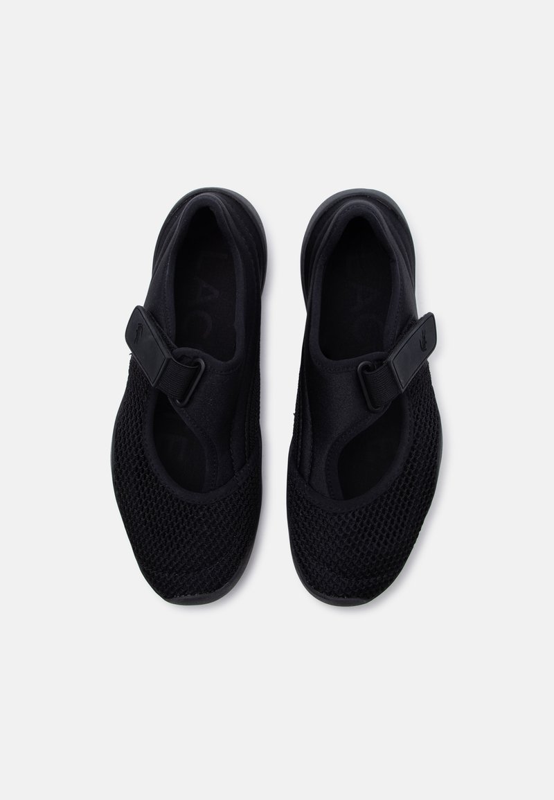 Coppia di scarpe Mary Jane nere in rete con cinturino regolabile e punta arrotondata, viste dall'alto su sfondo bianco.