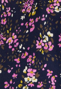 Tejido floral que presenta pequeñas flores rosas y blancas sobre un fondo azul marino, con toques de hojas marrones y verdes. Textura de algodón.