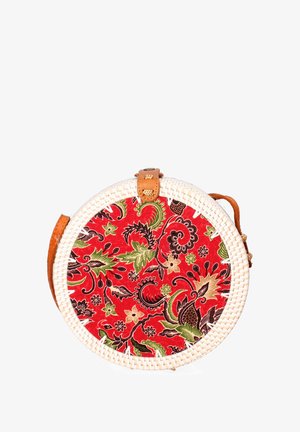 Round rattan bag with a red floral fabric pattern, featuring green and black accents, and a tan leather strap and handle.
