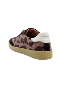 Sneaker w print w cętki z teksturowanym, futrzanym wierzchem, ciemnobrązowymi akcentami, białą zakładką na pięcie oraz beżową gumową podeszwą.