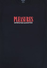 Czarna bawełniana koszulka z okrągłym dekoltem, na której widnieje wyraźny czerwony napis "PLEASURES" nad "SATISFACTION GUARANTEED" w białym kolorze.