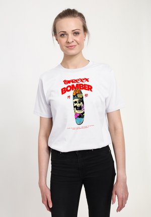 Bílý tričko s barevným grafickým designem lebky a skateboardu, s červeným textem "Street Bomber" a rokem "1990."