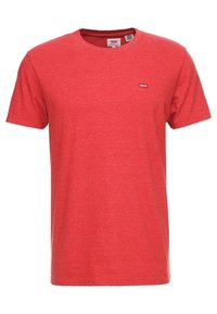 T-shirt en coton rouge avec un col rond, des manches courtes et un petit logo Levi's sur la poitrine. Tissu légèrement texturé.