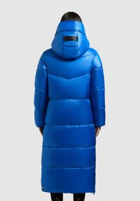 Blauer Puffer-Mantel mit Kapuze, glänzender Oberfläche, Chevron-Muster auf dem Rücken und Logo-Akzent in der Nähe des Kragens. Lange Ärmel und oberschenkellang.