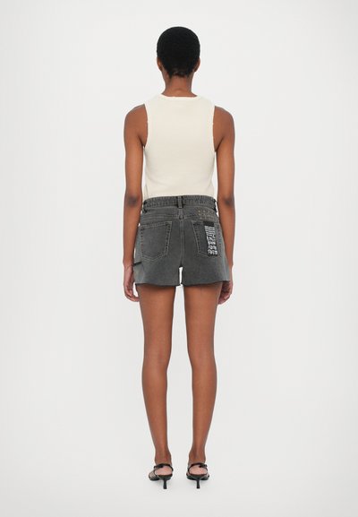 Black denim shorts with frayed hem and two rear pockets, featuring printed text detail on the right pocket and a flat waistband.