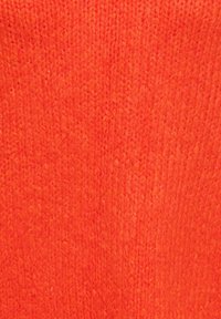 Stofstaal van gebreide stof in feloranje, met een gestructureerde weving met zichtbare vezels en een gladde afwerking over het oppervlak.