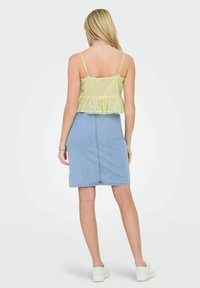 Yellow gingham peplum top with lace trim, paired with a light blue denim pencil skirt, worn with white slip-on shoes. Textured knit fabric.
