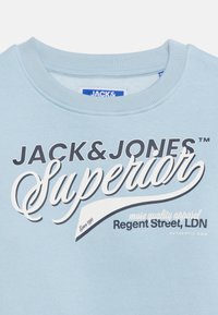 Φούτερ ανοιχτού γαλάζιου χρώματος με ριμπ λαιμόκοψη, διακοσμημένο με την επιγραφή "JACK & JONES Superior Regent Street, LDN" σε μαύρο και λευκό κείμενο.