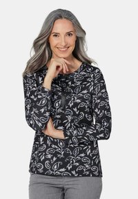 Langsleeve top met een zwarte basis, voorzien van een bloemen- en abstract patroon in grijs- en blauwtinten. Ronde halslijn met een strikdetail.