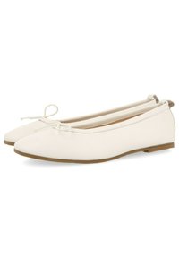 Bailarinas blancas con un acabado suave, punta afilada y un lazo decorativo. Suela plana con un diseño flexible. Sin herrajes ni acentos visibles.