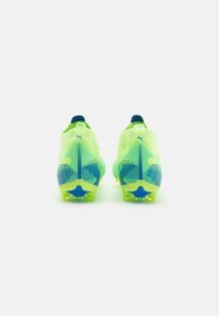 Scarpette da calcio giallo neon con tomaia testurizzata, dettagli blu e un distintivo motivo a stelle dei tacchetti sulla suola.